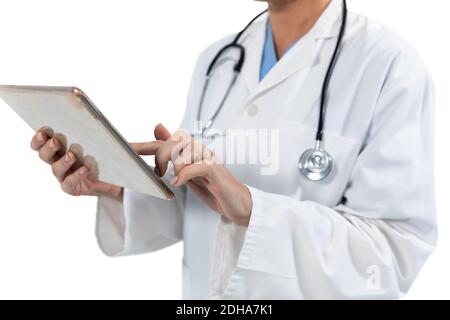 Mid section of female doctor using digital tablet against white background Stock Photo