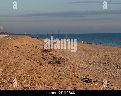 People seen walking on the beach of Bognor Regis on a sunny but cold afternoon in November 2020. Stock Photo