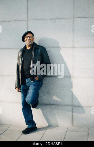 Full length portrait of senior man standing against wall Stock Photo