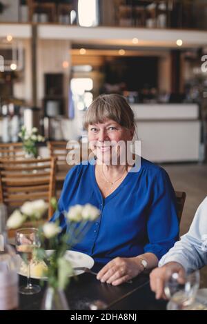 Portrait of smiling senior woman having lunch and socializing in restaurant Stock Photo