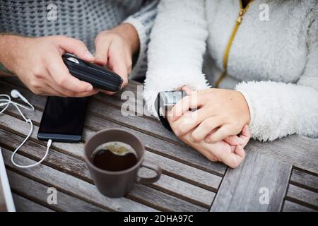 High angle midsection of caretaker and disabled woman using technologies at table Stock Photo