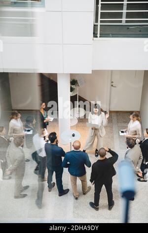 High angle view of female professional with laptop talking to colleagues outside office Stock Photo