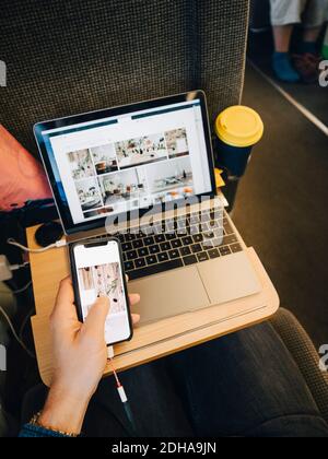 High angle view of man using mobile phone while sitting in airplane Stock Photo