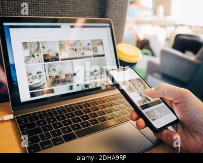 Cropped image of person using mobile phone and laptop in airplane Stock Photo