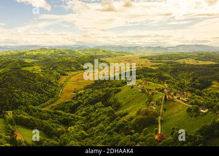 Aerial view of of green hills and vineyards with mountains in background