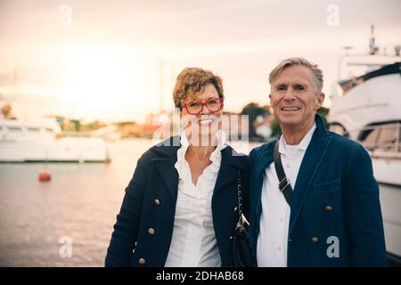 Portrait of confident senior couple smiling at harbor Stock Photo