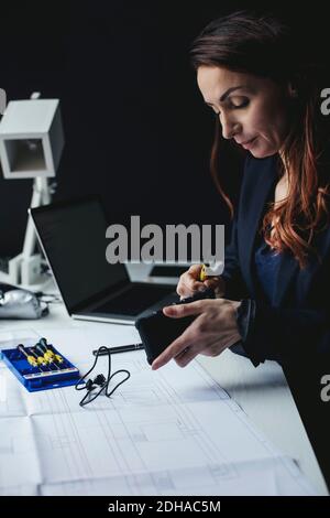 Female businesswoman working on portable hard drive at desk in home office Stock Photo