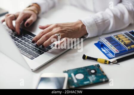 Cropped image of businesswoman using laptop on table in home office Stock Photo