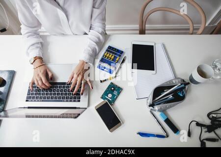 Midsection of businesswoman using laptop on table at home office Stock Photo