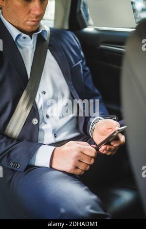 Mature businessman using mobile phone while sitting in car Stock Photo