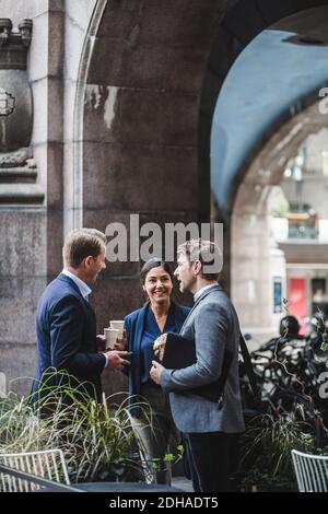 Happy business people talking at sidewalk cafe Stock Photo