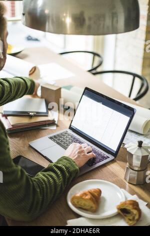 Male entrepreneur using laptop while working at home Stock Photo