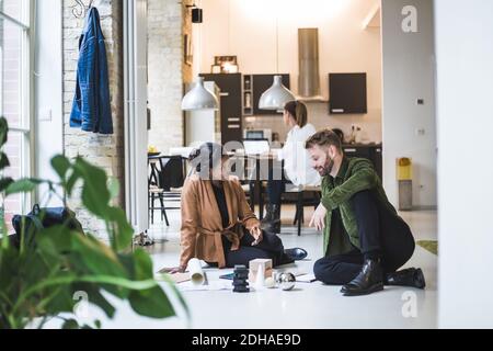 Smiling architects discussing while female entrepreneur working in background at home office Stock Photo