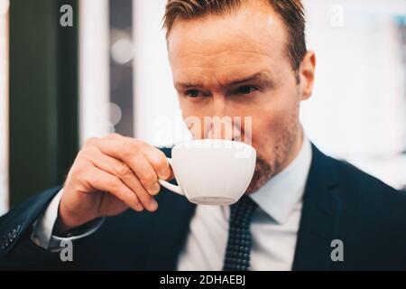 Mature businessman drinking coffee in cafe Stock Photo