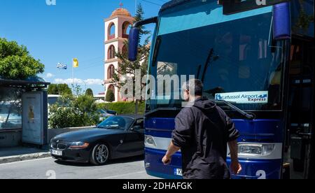 April 22, 2019, Limassol, Cyprus. Blue bus on the background of the bell tower of the Christian Church at the Limassol bus station Stock Photo