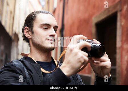 Close-up of smiling young man looking at camera while standing against buildings Stock Photo
