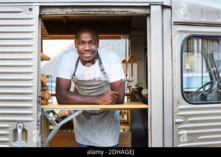 Portrait of confident mid adult male owner standing in food truck Stock Photo