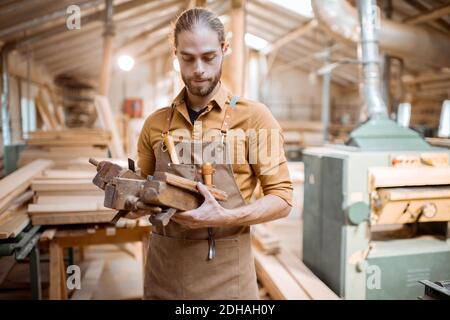 Handsome carpenter with vintage working tools in the carpentry workshop Stock Photo