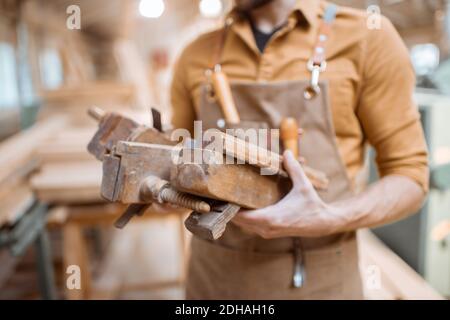 Handsome carpenter with vintage working tools in the carpentry workshop Stock Photo