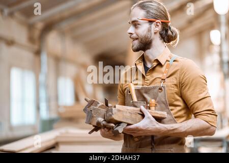 Handsome carpenter with vintage working tools in the carpentry workshop Stock Photo