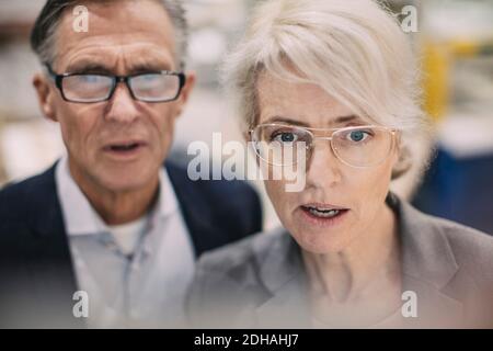 Close-up of serious business people wearing eyeglasses at industry Stock Photo