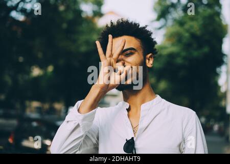 Young man gesturing while standing in city Stock Photo