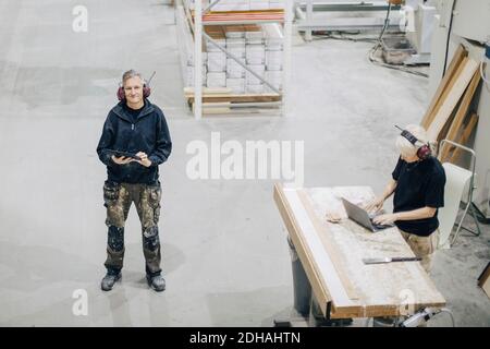 High angle view of male and female workers using technology at industry Stock Photo