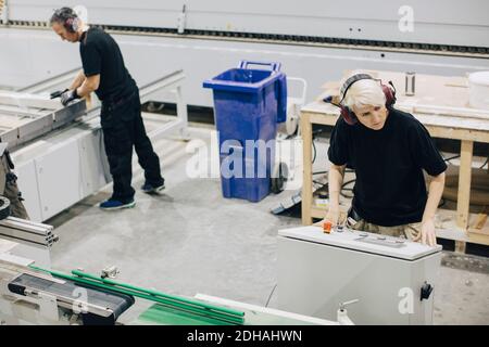 High angle view of male workers operating machines in industry Stock Photo