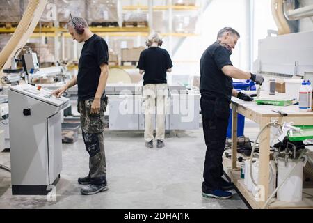 Full length of male and female workers working at industry Stock Photo