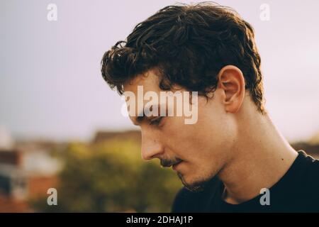Close-up of thoughtful young man looking down at terrace Stock Photo