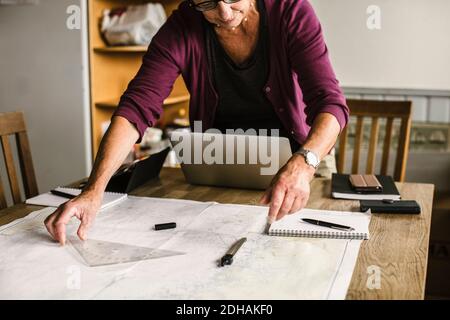 Midsection of senior female instructor at table during navigation course Stock Photo