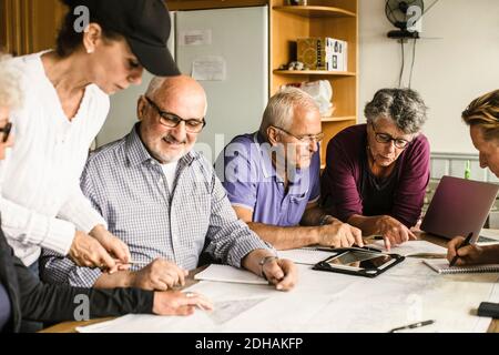 Senior men and women discussing at table during navigation course Stock Photo