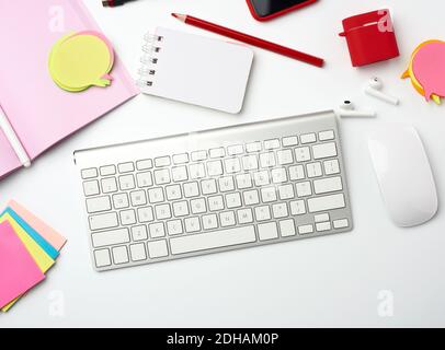 White wireless keyboard, computer mouse and paper notebook Stock Photo