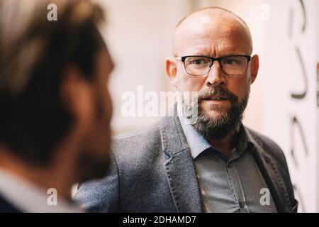 Close-up of businessman discussing with colleague at office Stock Photo
