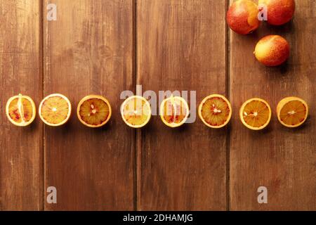 Organic blood oranges, whole and cut, shot from the top on a dark rustic background Stock Photo