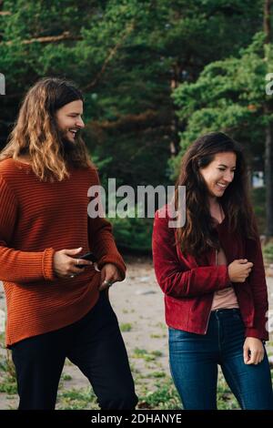 Happy friends spending leisure time together in forest Stock Photo