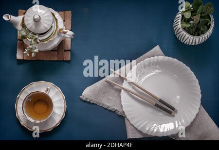 Empty white plate, chopsticks and herbal tea Stock Photo