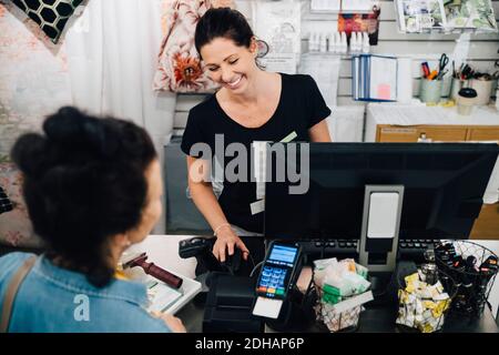 High angle view of Female customer paying at checkout in hardware store Stock Photo