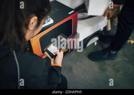 Female worker using mobile phone during delivery with coworker Stock Photo