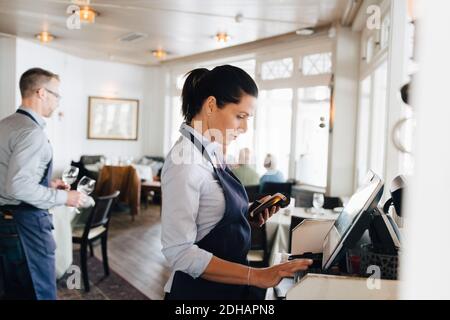 Woman using computer in restaurant Stock Photo