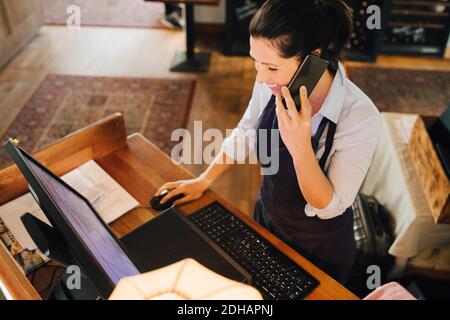 High Angle View of owner talking on phone in restaurant Stock Photo