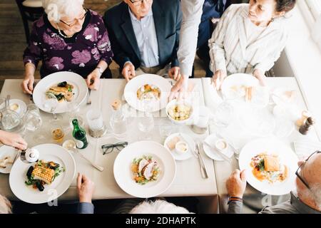 High angle view of Senior friends with food in restaurant Stock Photo