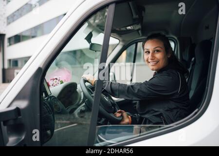 Portrait of smiling woman driving delivery van in city Stock Photo