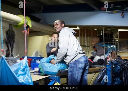 Male volunteers working at workbench in warehouse Stock Photo