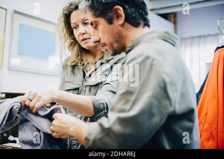 Low angle view of mature colleagues examining fabric at warehouse Stock Photo
