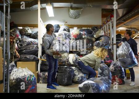 Colleagues stacking plastic sacks in warehouse Stock Photo