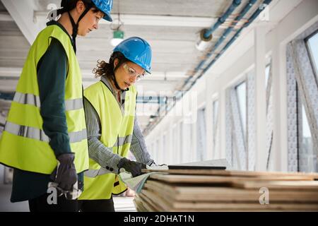 Female engineers discussing over blueprint at construction site Stock Photo