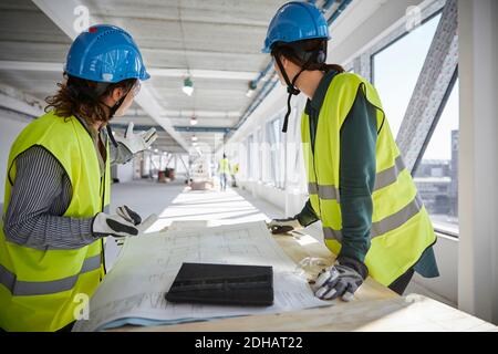 Female engineers planning over blueprint at construction site Stock Photo