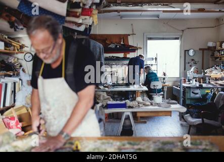 Male and female colleagues working at workshop Stock Photo