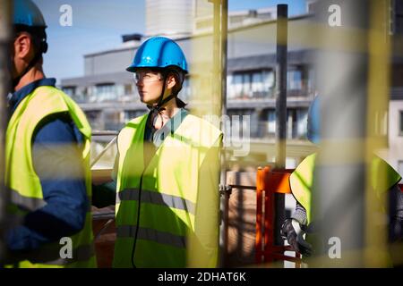 Male and female architects in protective workwear at construction site Stock Photo